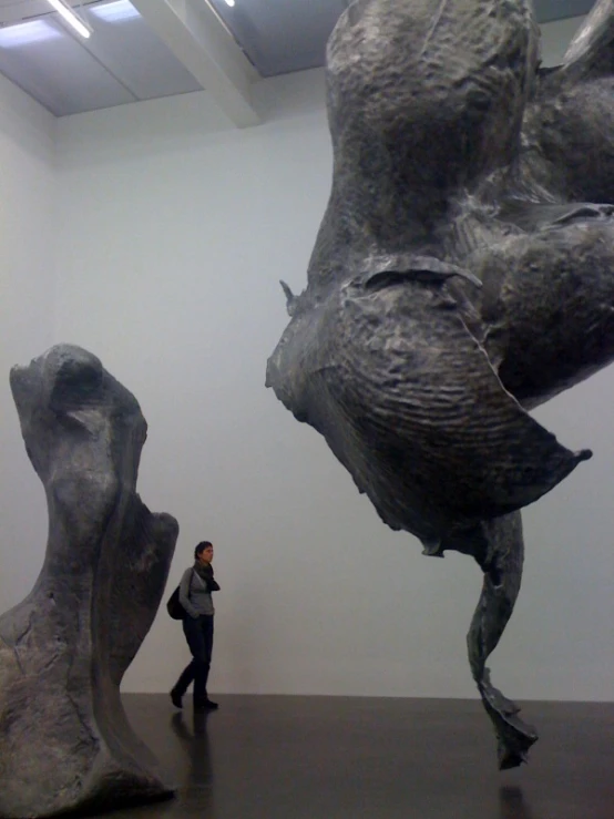 a man walking past two sculptures in a room