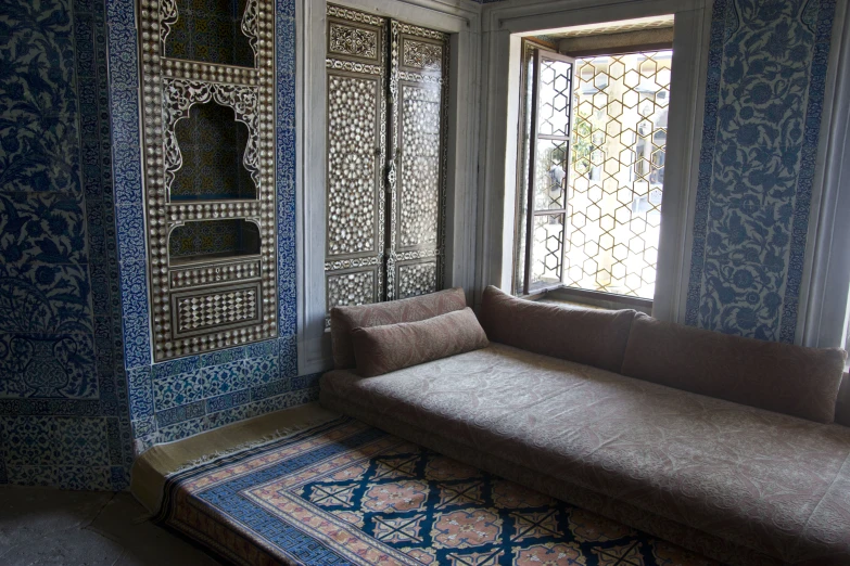 an ornate blue room with a couch and rug