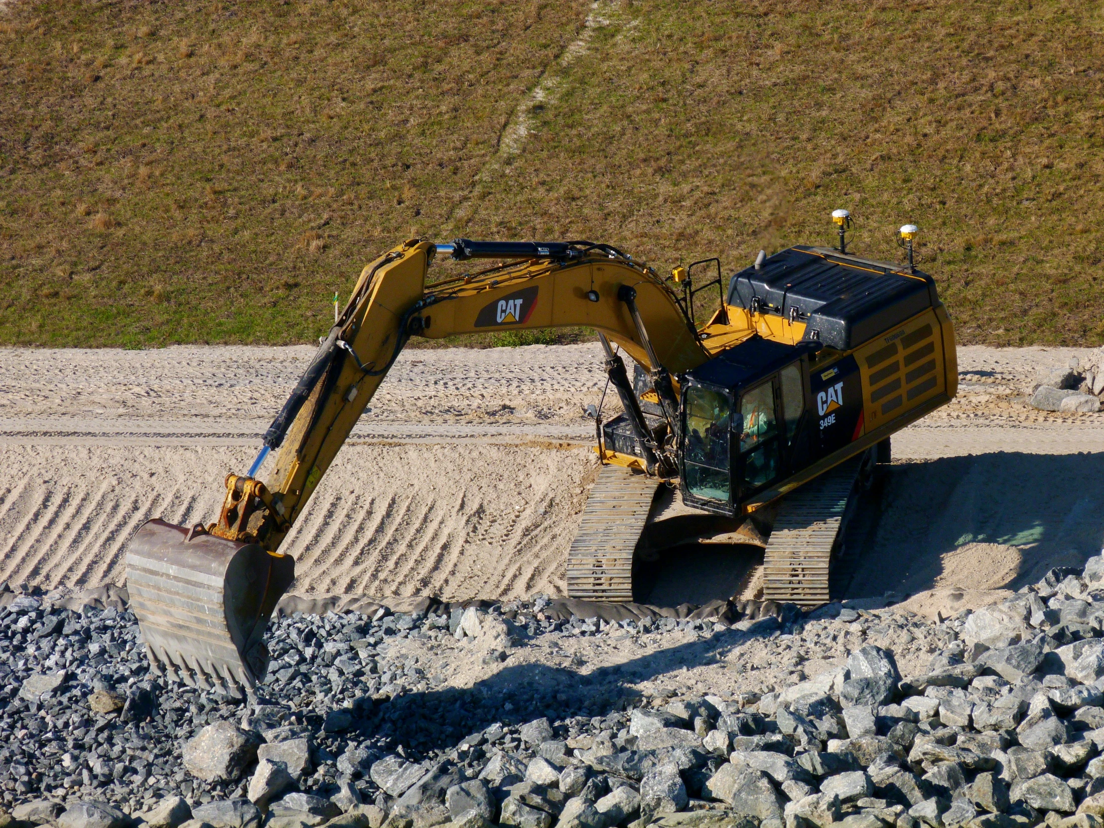 an excavator digging rocks to prepare a roadway