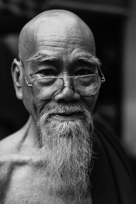 an old man with white beard and glasses is frowning