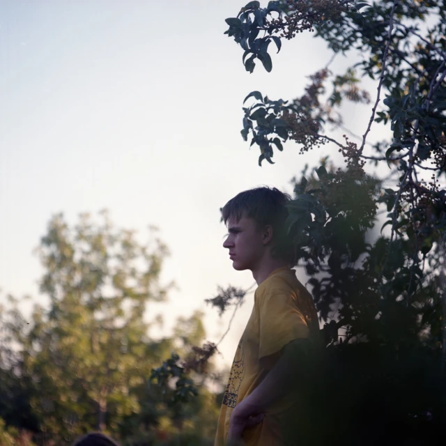 a young man with headphones is staring away from the camera