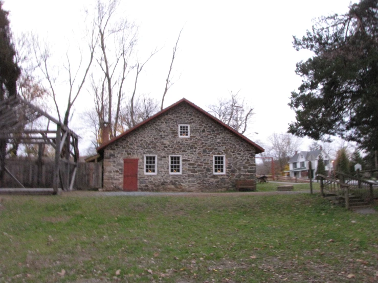 the back of a building with a red door and grass