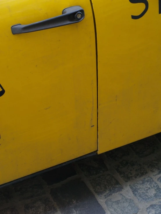 a yellow painted old car with black numbers