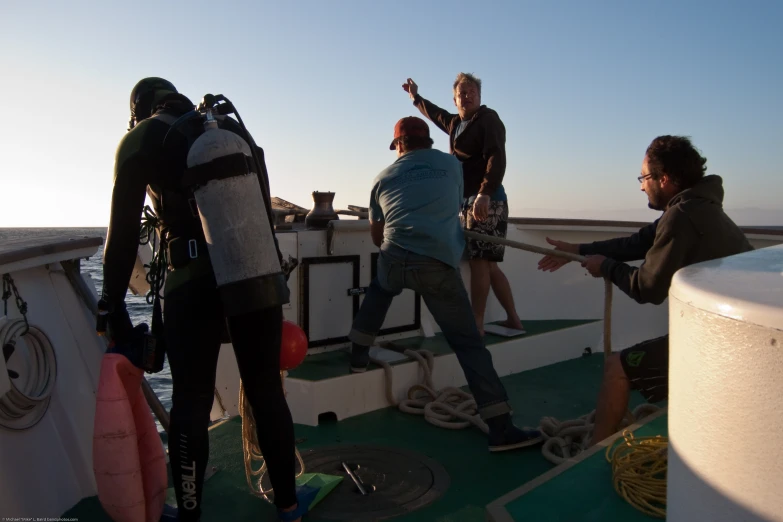 four men on a boat are observing soing