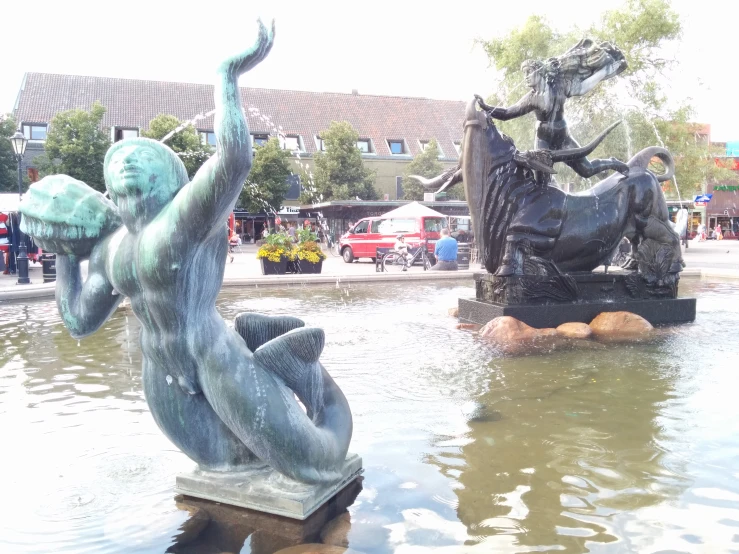 two fountains with statues of women and horses