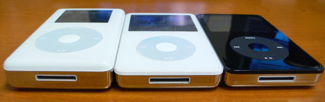 three ipods, all in different colors sitting on a table