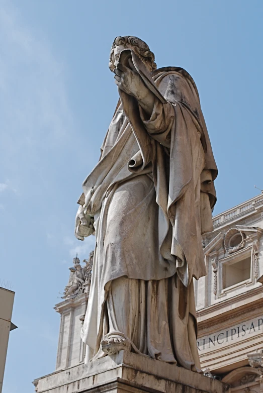 a statue of a man with a sword near a building