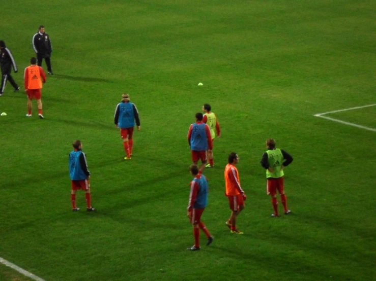 men are standing on the field wearing bright colors