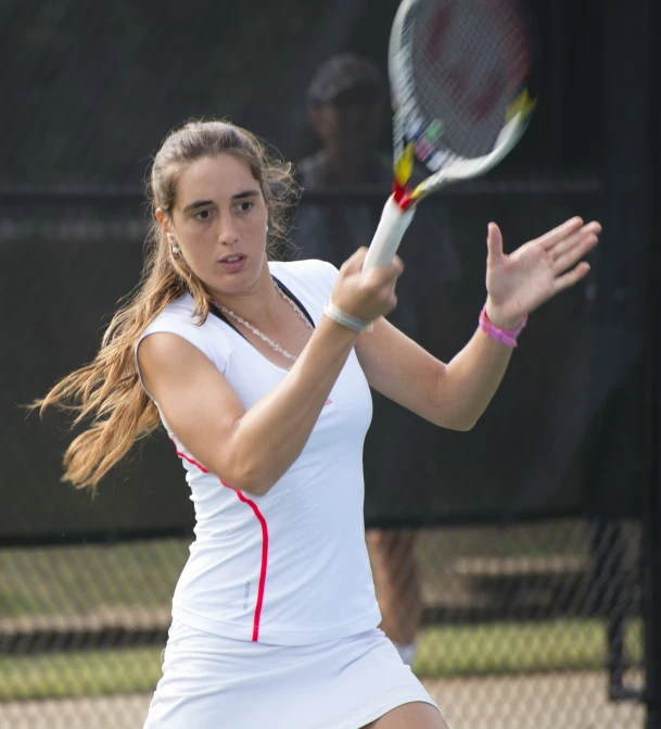 a woman is swinging her tennis racket at a ball