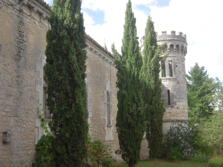 an old building has large hedges and a tower on it