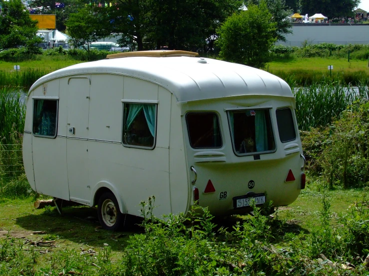 an old trailer is parked near the water