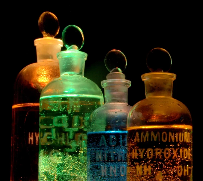 some bottles are filled with bright colored liquids