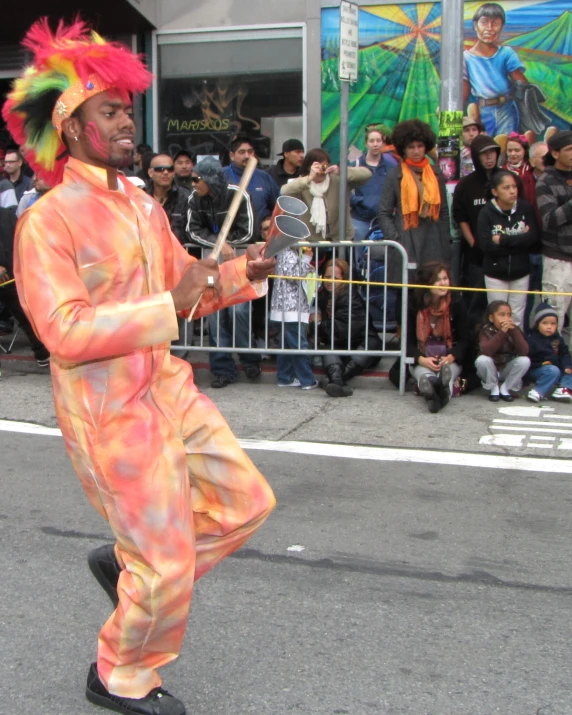 a man wearing clown costume walking down a street