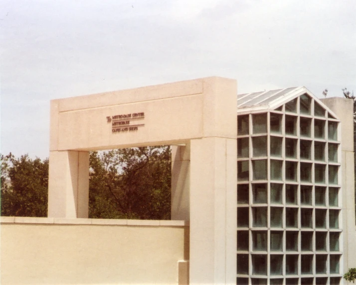 a large cement building with a white arch with a sign that reads the national memorial center