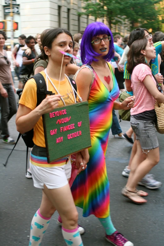 two woman with different outfits walking through a street