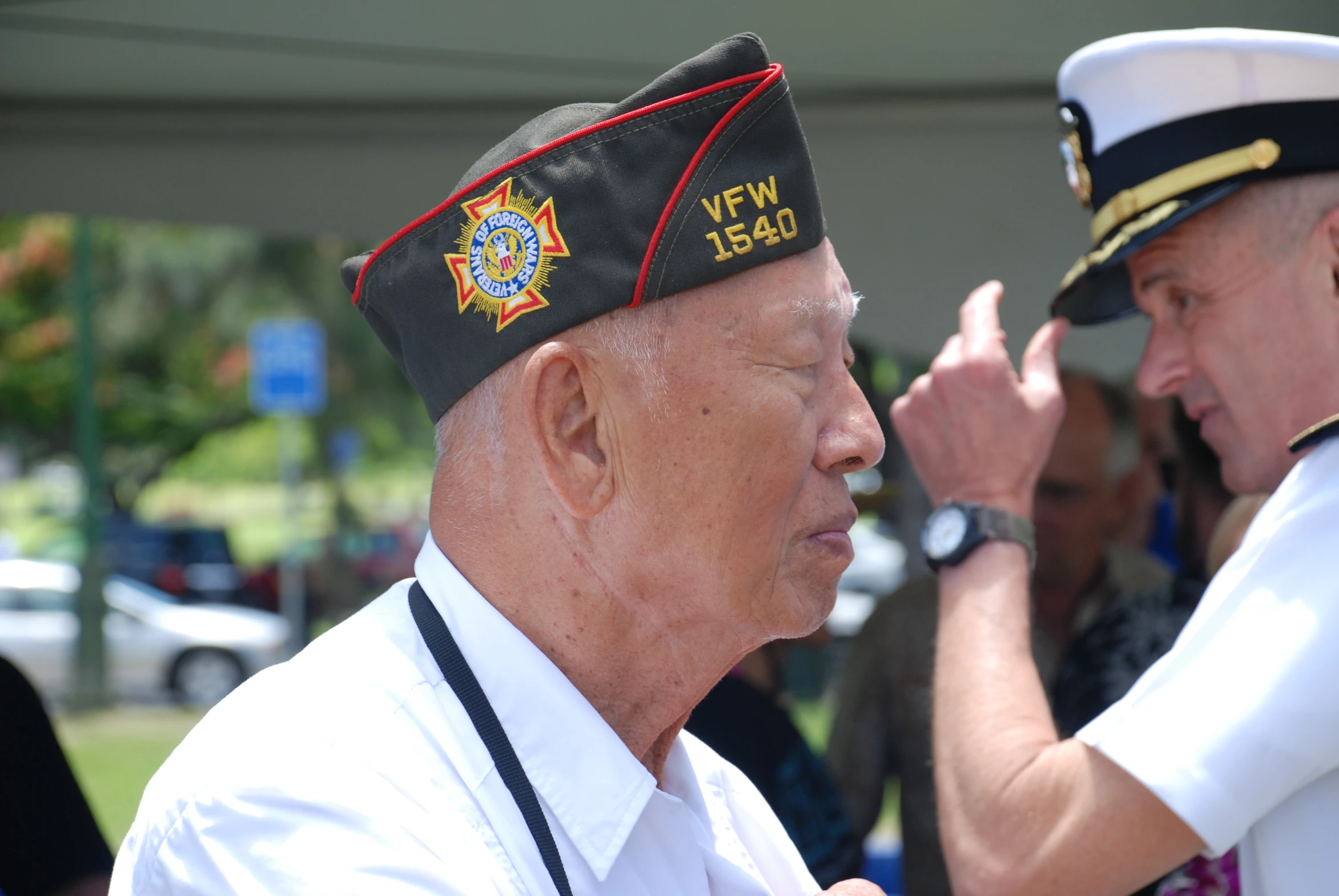 an older man saluting the colors of his hat