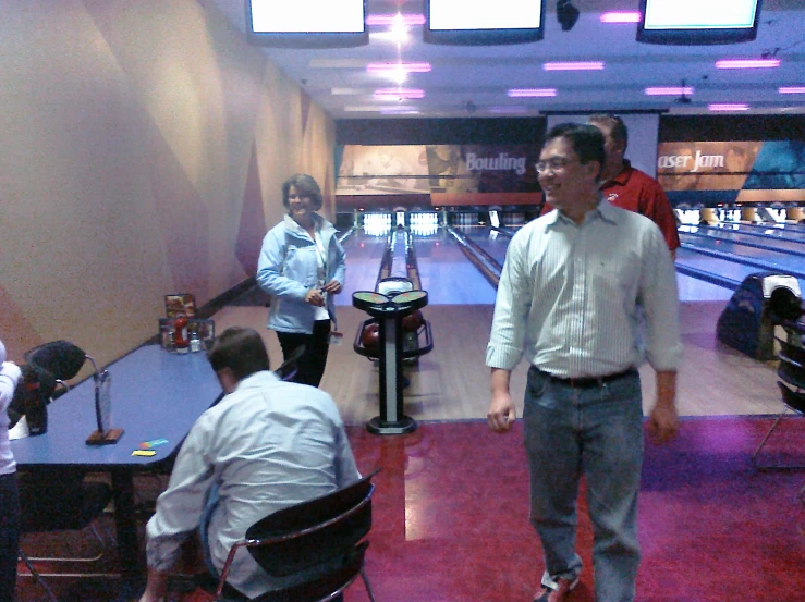 people gathered around a bowling alley at the bowling alley