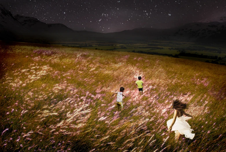 two young children running through a grassy field