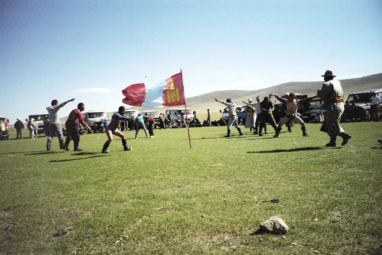 a group of people playing with kites in the middle of a field