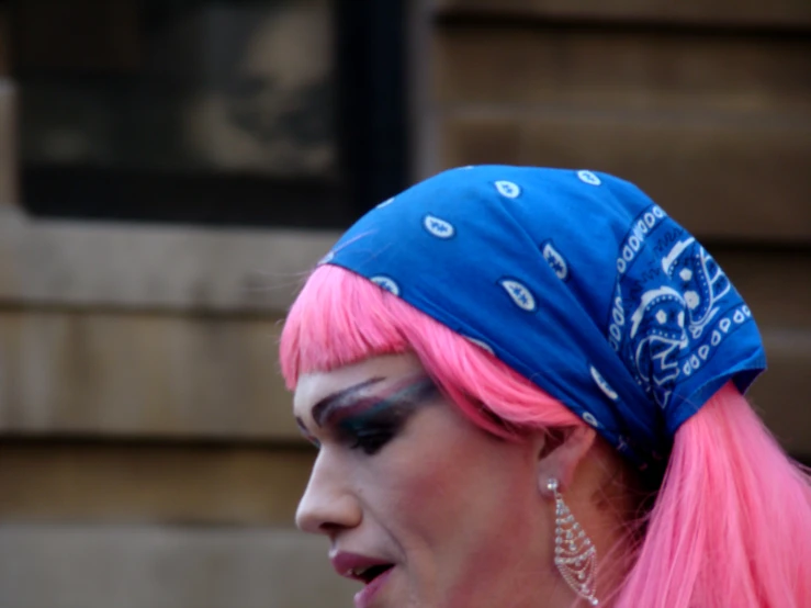 a person with pink hair wearing a blue bandanna