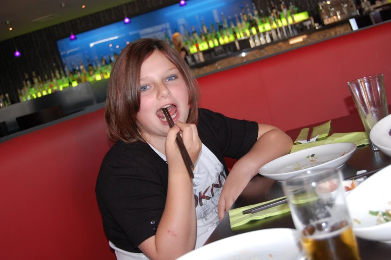 a woman with food in her mouth at a restaurant