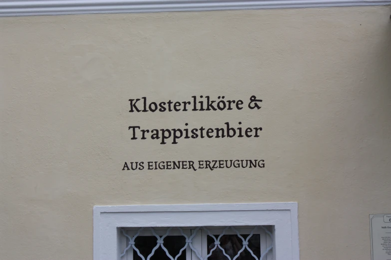 a wall sign with a glass window and sign in german