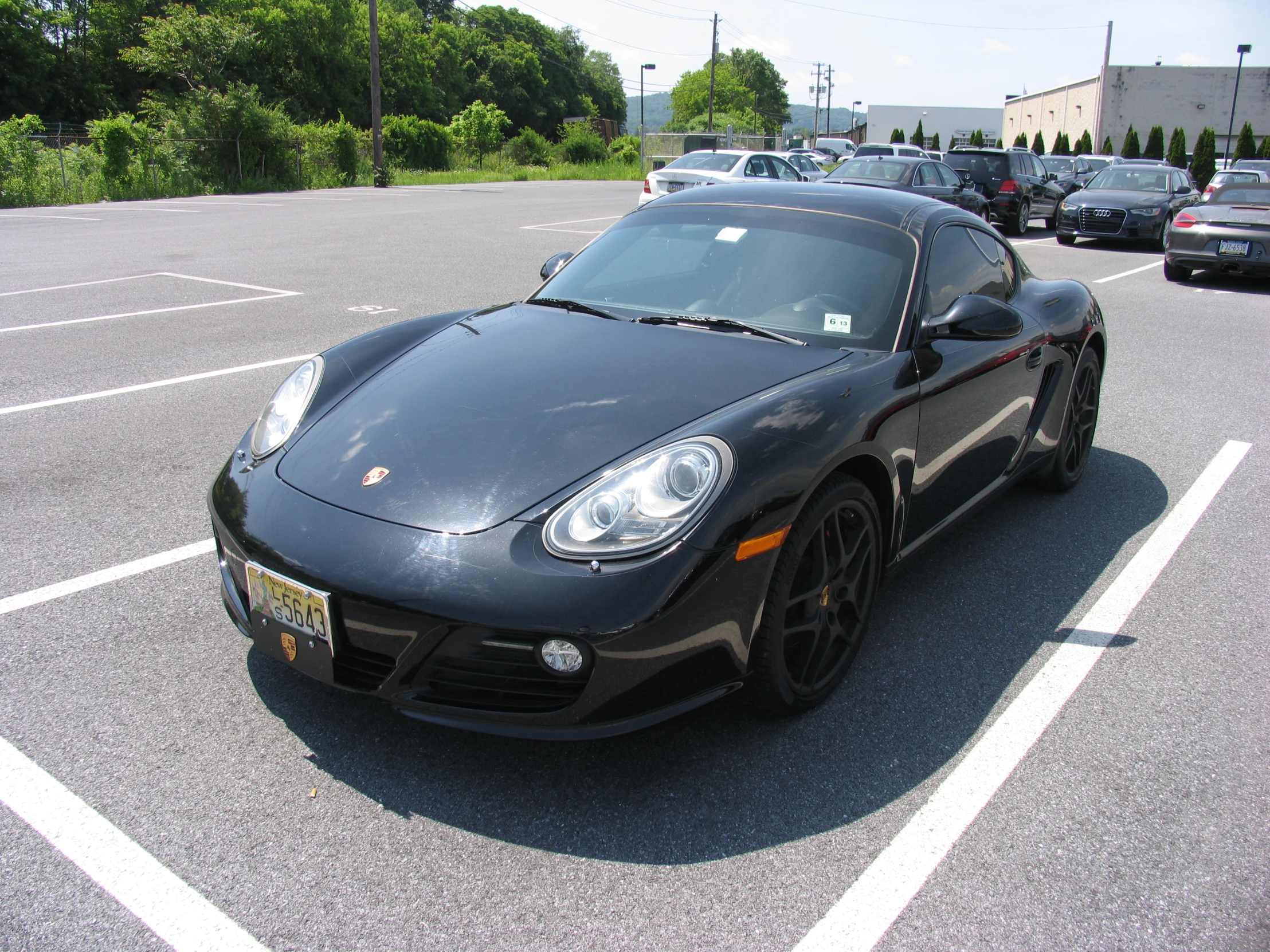 a large black sports car is in the parking lot