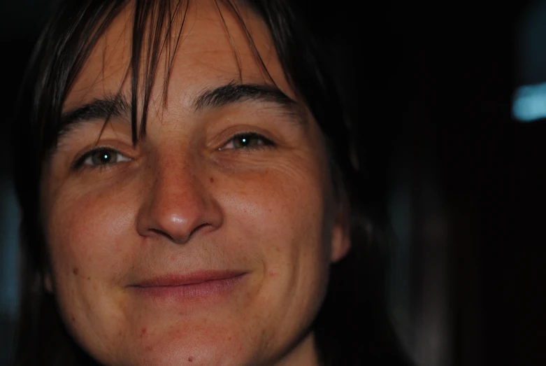 a woman with long hair and brown eyes staring into the camera