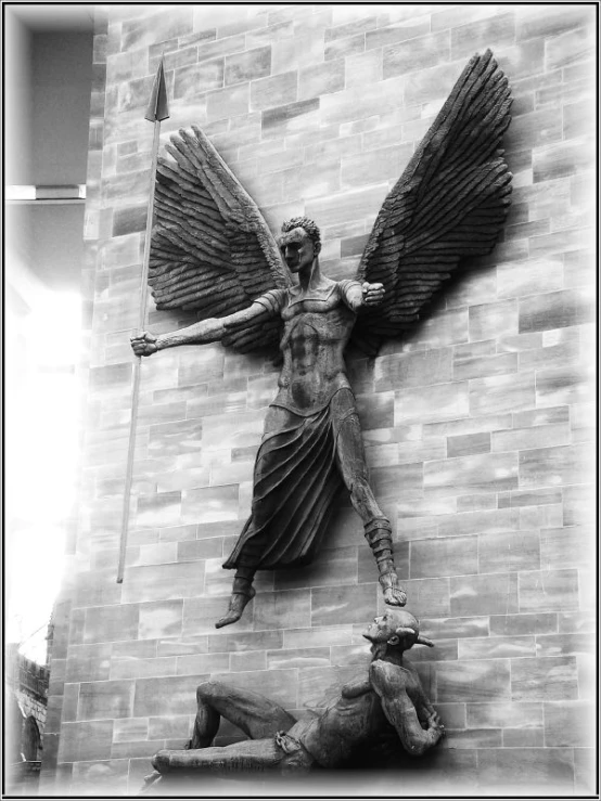 an angel statue above a man laying on the ground