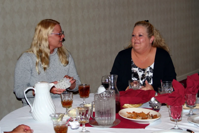 a group of women sitting around a white table