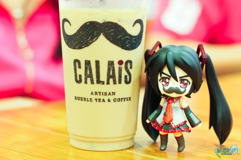 a small figurine next to a drink