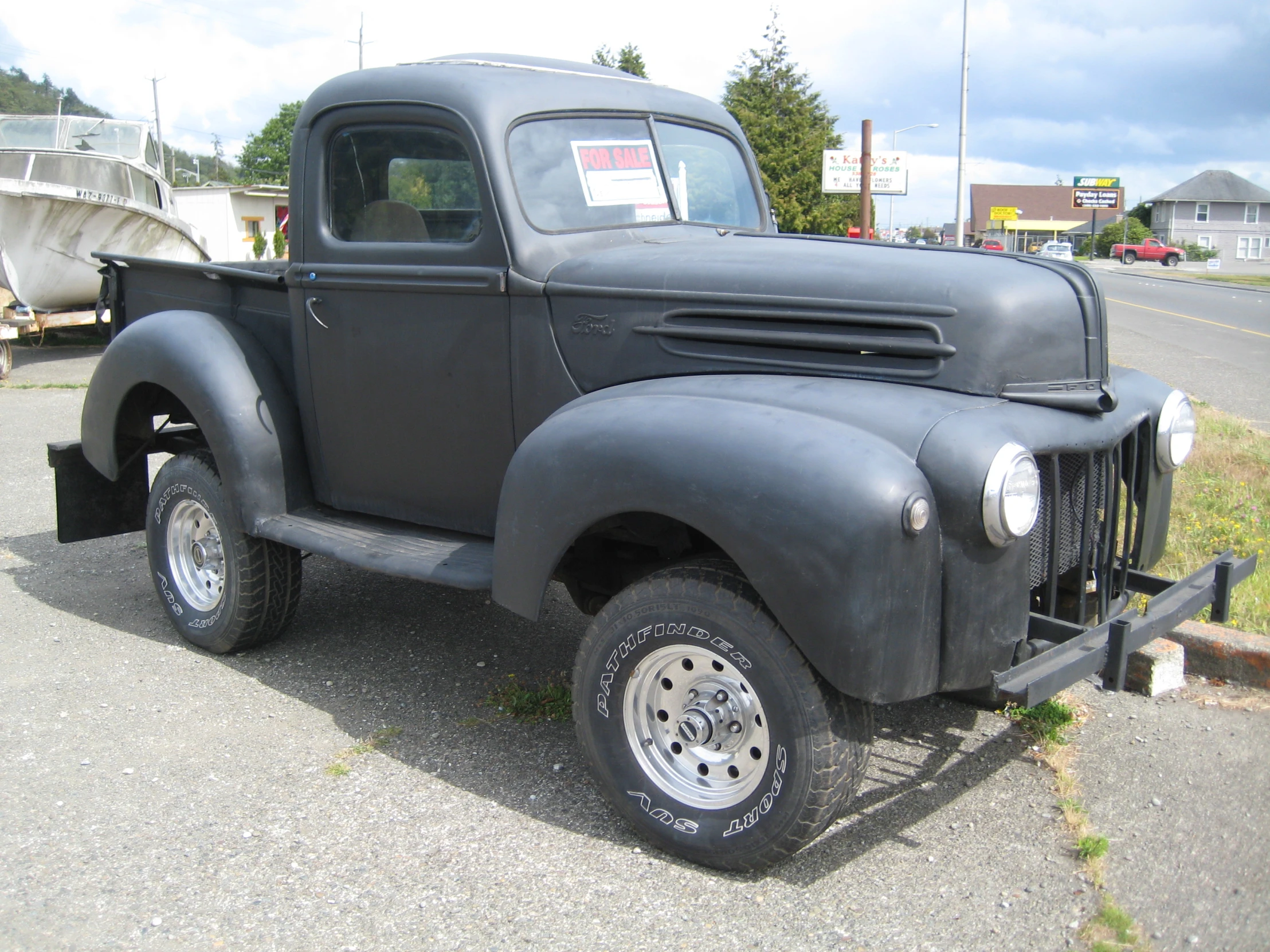 an older black pickup truck is parked on the street