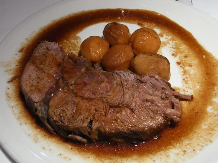 some meat is covered with potatoes and gravy