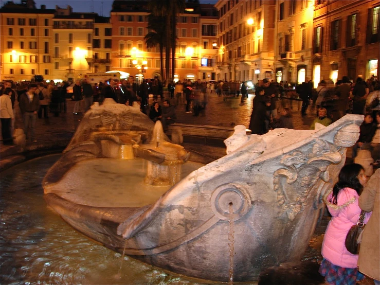 a small child standing near an ornate stone fountain