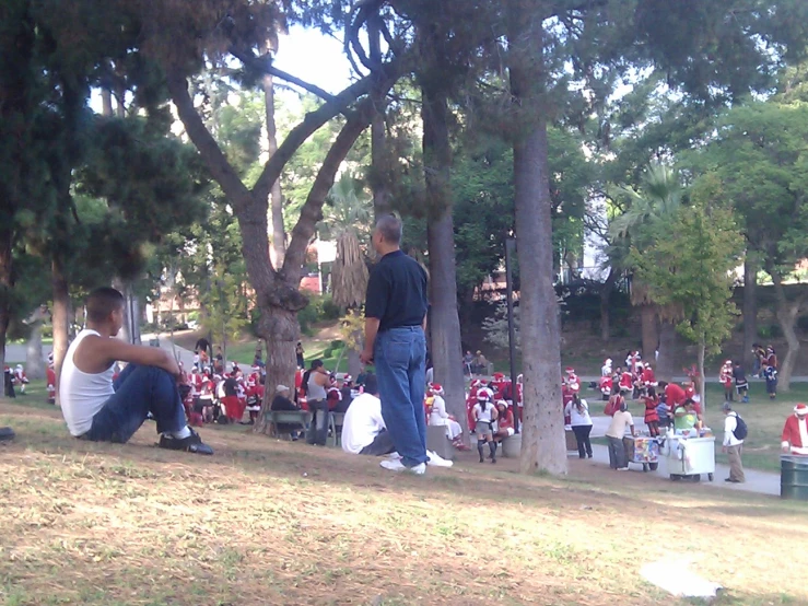 people sit on benches under the trees and talk