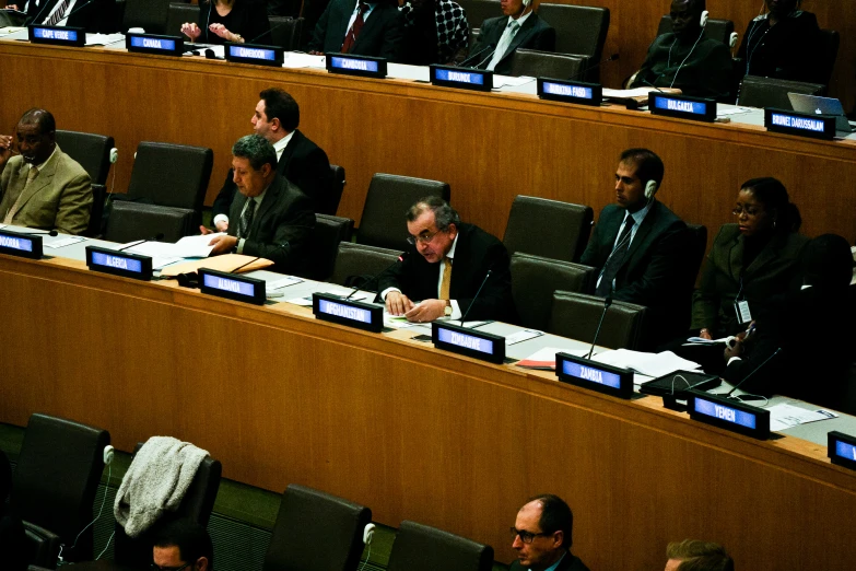 a group of people are sitting in a committee room