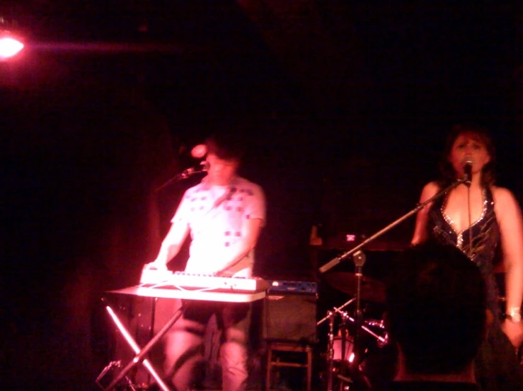 a man and woman standing at a music stage