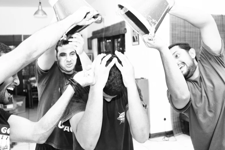 four men lifting up a bowl in the air