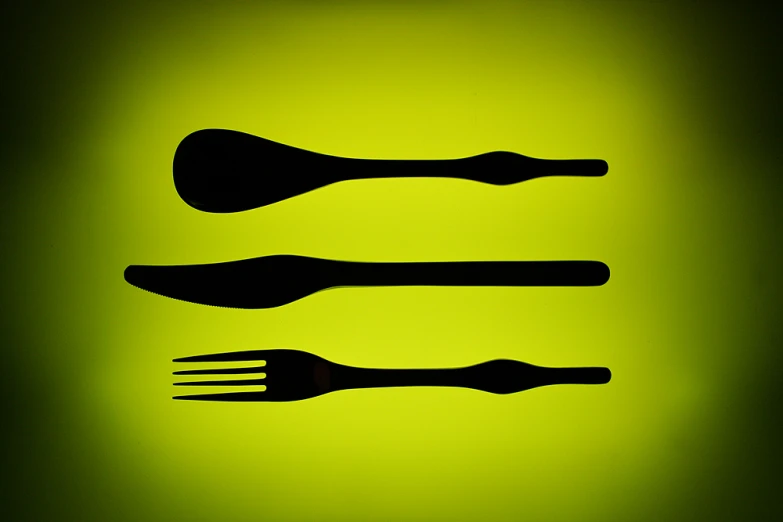 the silhouette of a fork, knife and spoon is placed on the green light