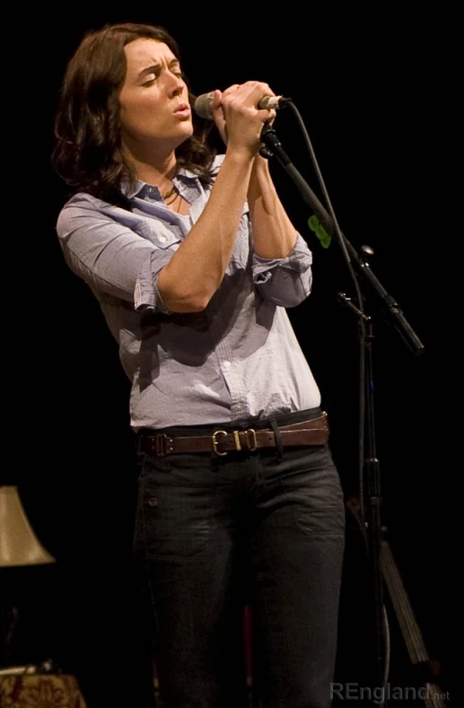 a woman is singing into the microphone