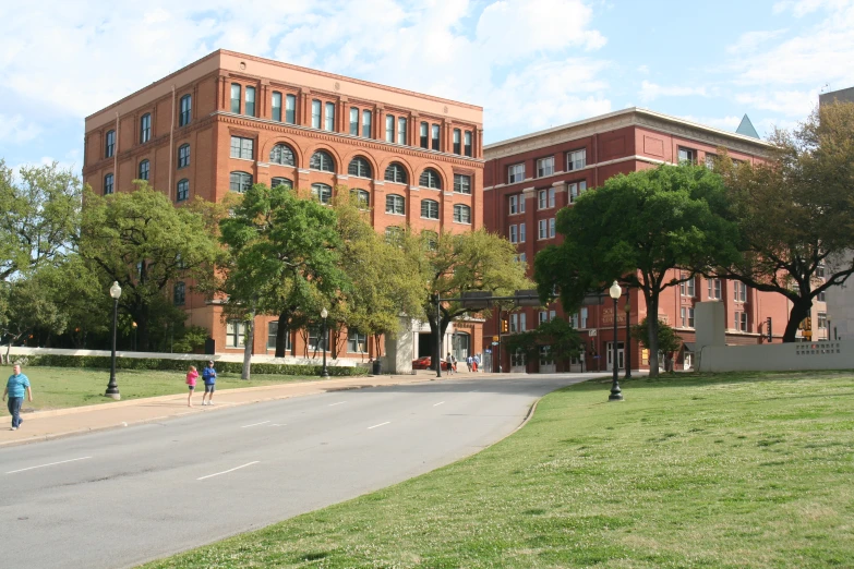 two people are walking down the street towards a building