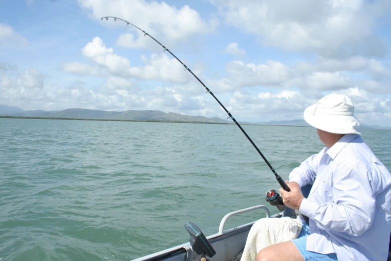 a man holding a fish with a fishing rod