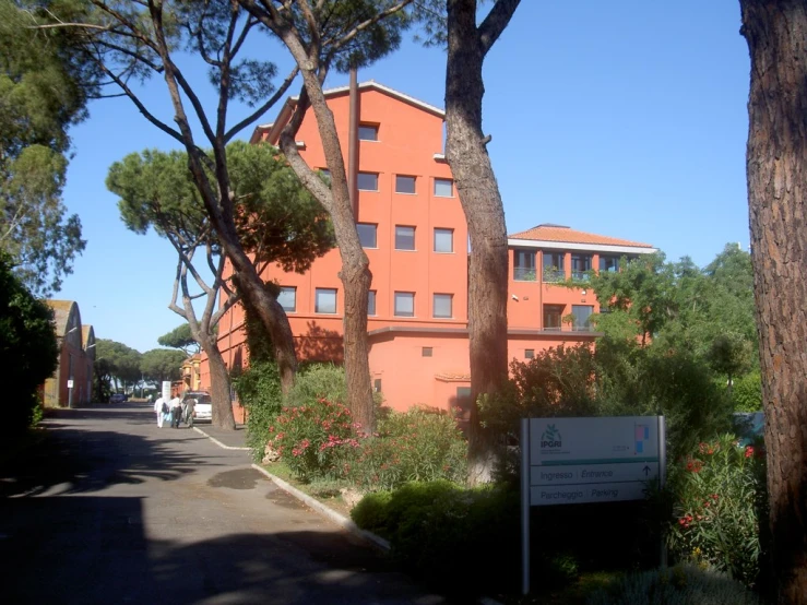 a red building that is near trees on the street