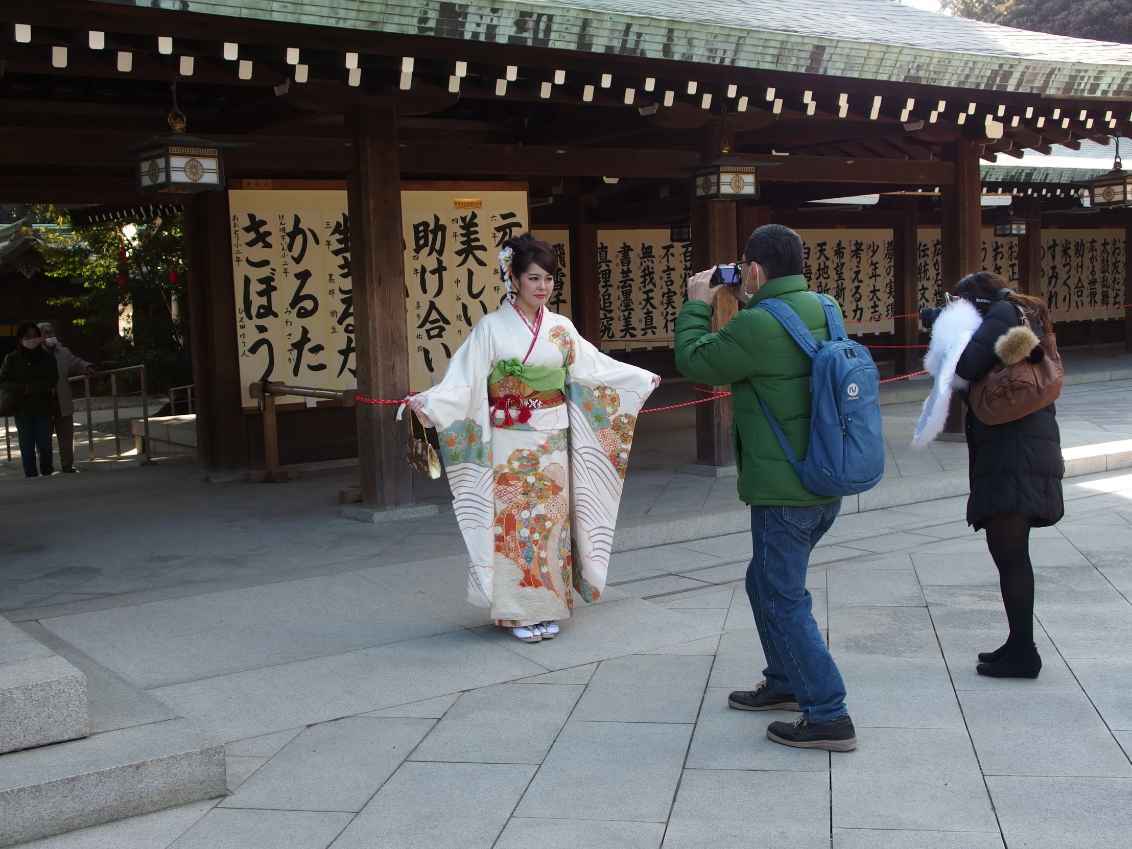 there is a woman in kimono walking on the sidewalk