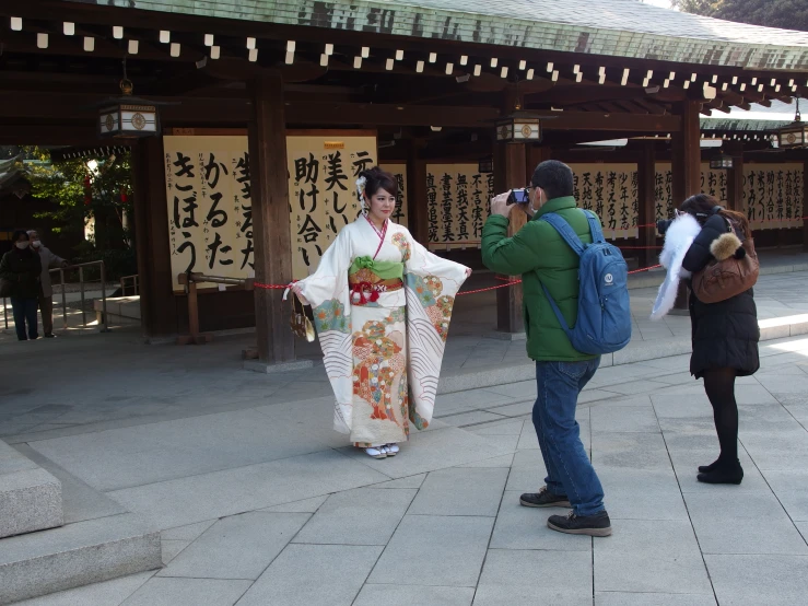 there is a woman in kimono walking on the sidewalk