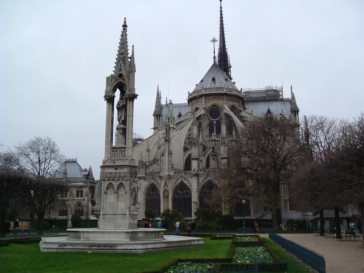 a large gothic stone building with a fountain in the foreground