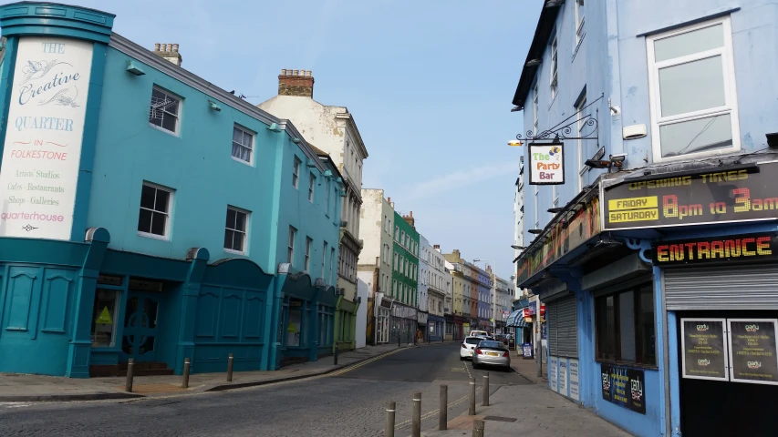 blue buildings sit in a street in a small city