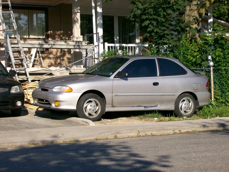 a car and ladder sit outside a house