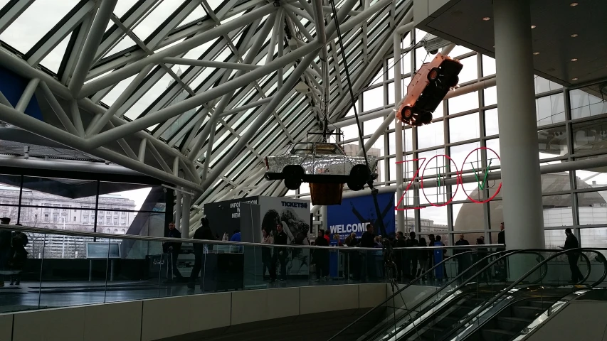 people walk in a very large building and some escalators