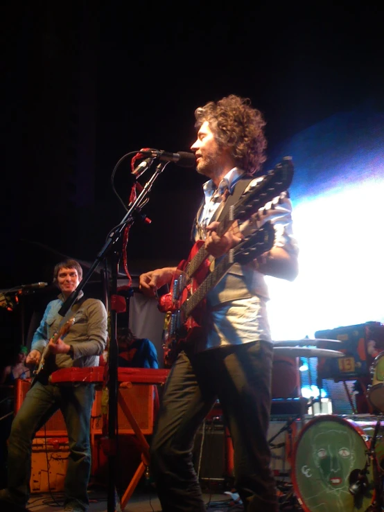 man with a guitar on stage playing a song